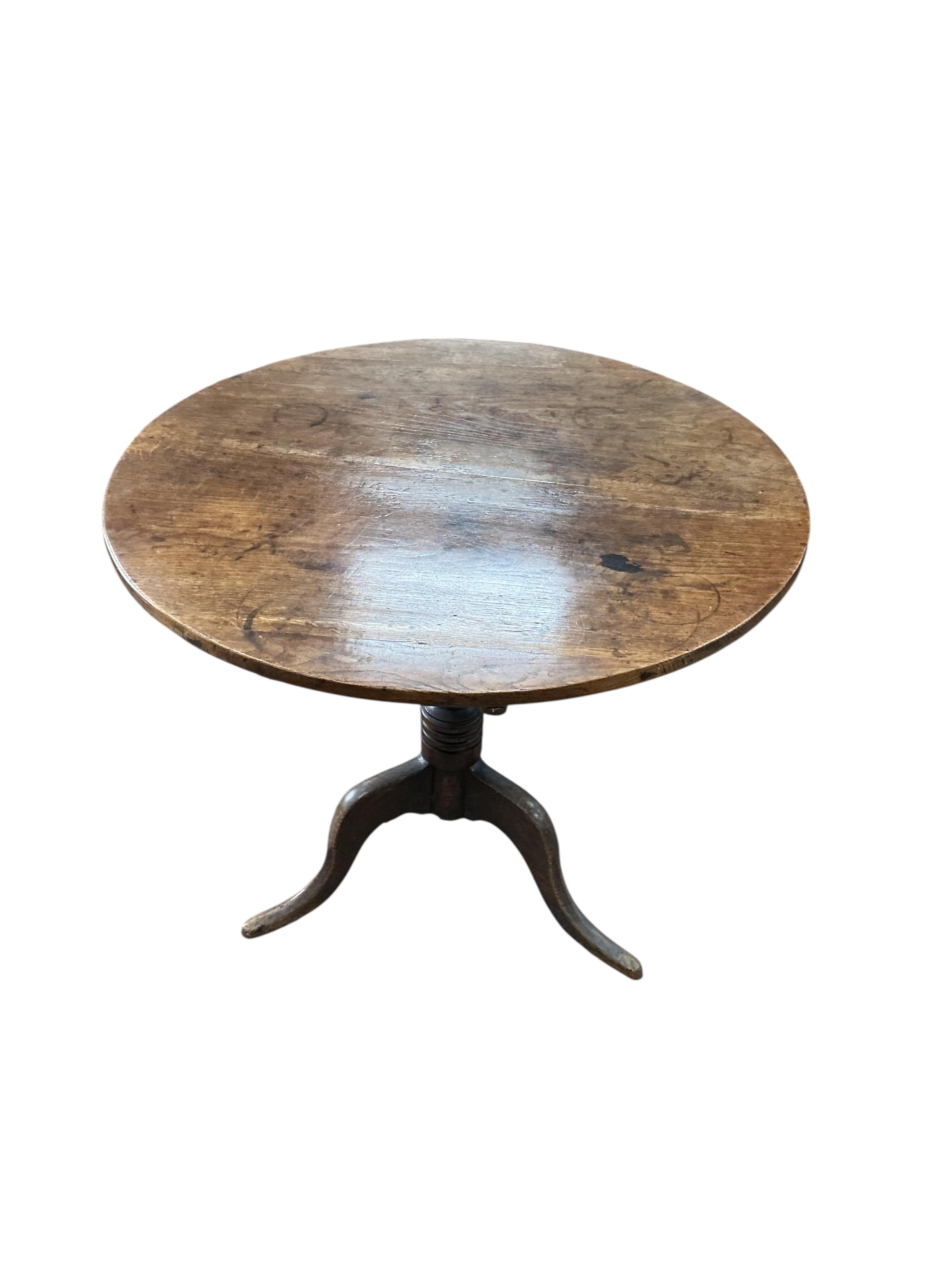A George III circular oak tilt top tripod tea table, diameter 82cm, height 70cm
